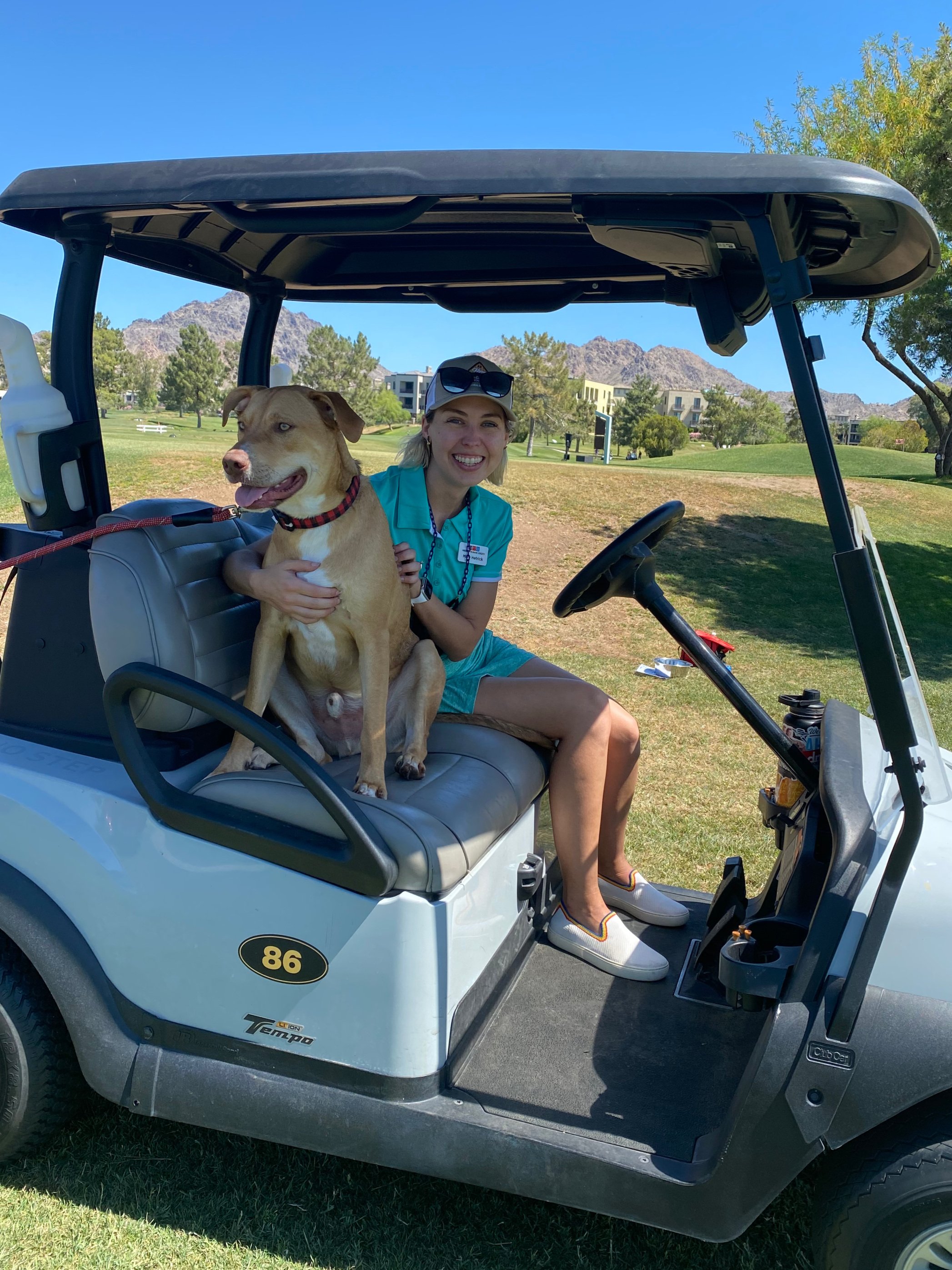 Mary Hetrick with her dog on a golf cart at an outdoor event