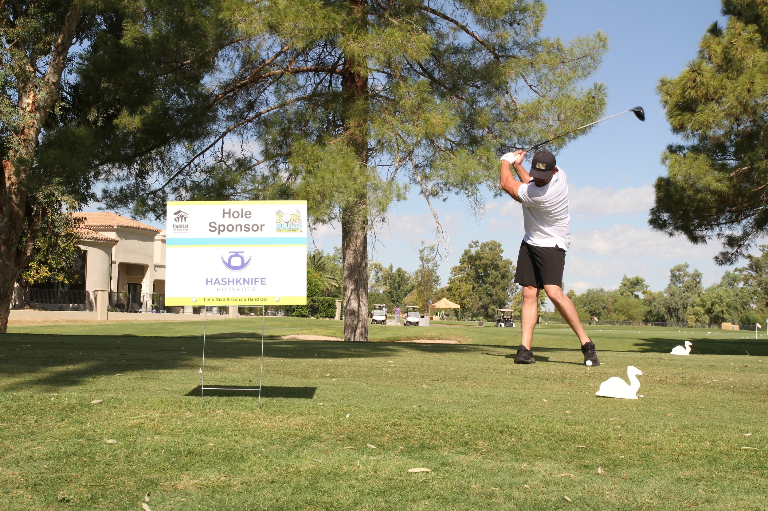 Event volunteer holding a colorful ribbon at an outdoor Habitat for Humanity event